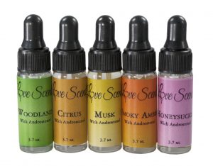Five small eyedropper bottles with black caps and multi colored labels. The labels show, in order, "Woodland," "Citrus," "Musk," "Smoky Amber," and "Honeysuckle"
