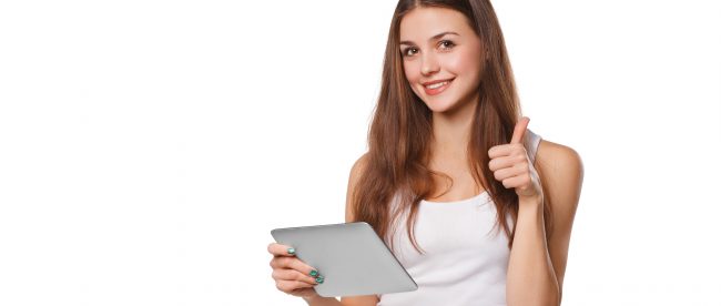 Young woman in white tank top looking up from her tablet and giving a thumbs up sign
