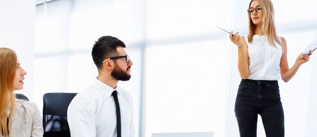 Woman in business attire leading a metting in a corporate boardroom