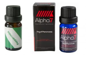 Peppermint essential oil, in a brown screw-cap bottle with a green and white label, sits next to Alpha-7 Unscented, a blue screw-cap bottle with a black and red label, and Alpha-7 Unscented's box, a black box with red markings and white and red text.